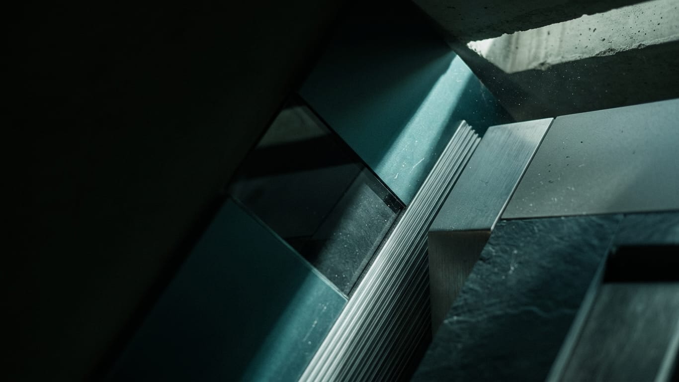 Illustration for this article: Building a Defensible Verification Chain. A shaft of hard daylight crossing a raw concrete soffit, dust suspended in the beam.