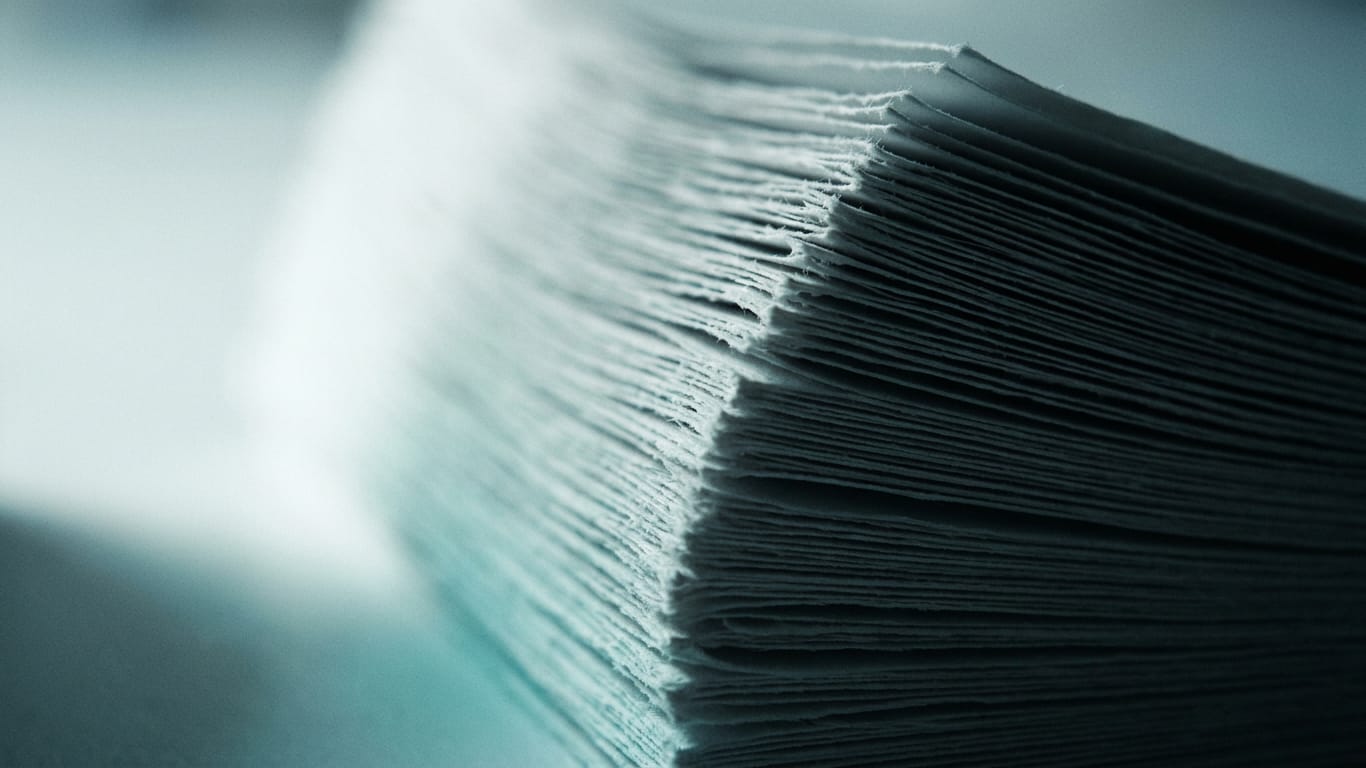 Illustration for this article: more and more severe incidents in which AI escapes control. The cut edges of a thick stack of blank paper, fanned slightly, raking light along the fibres.