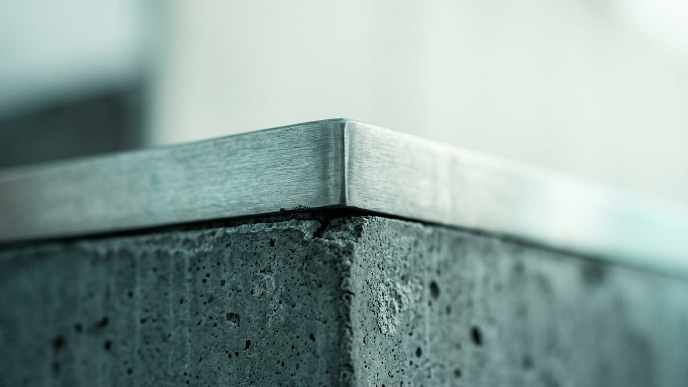 Illustration for this article: European Commission uses AI Act powers for the first time against more than 30 AI companies. Poured concrete meeting brushed steel at a tight seam, the joint slightly misaligned.