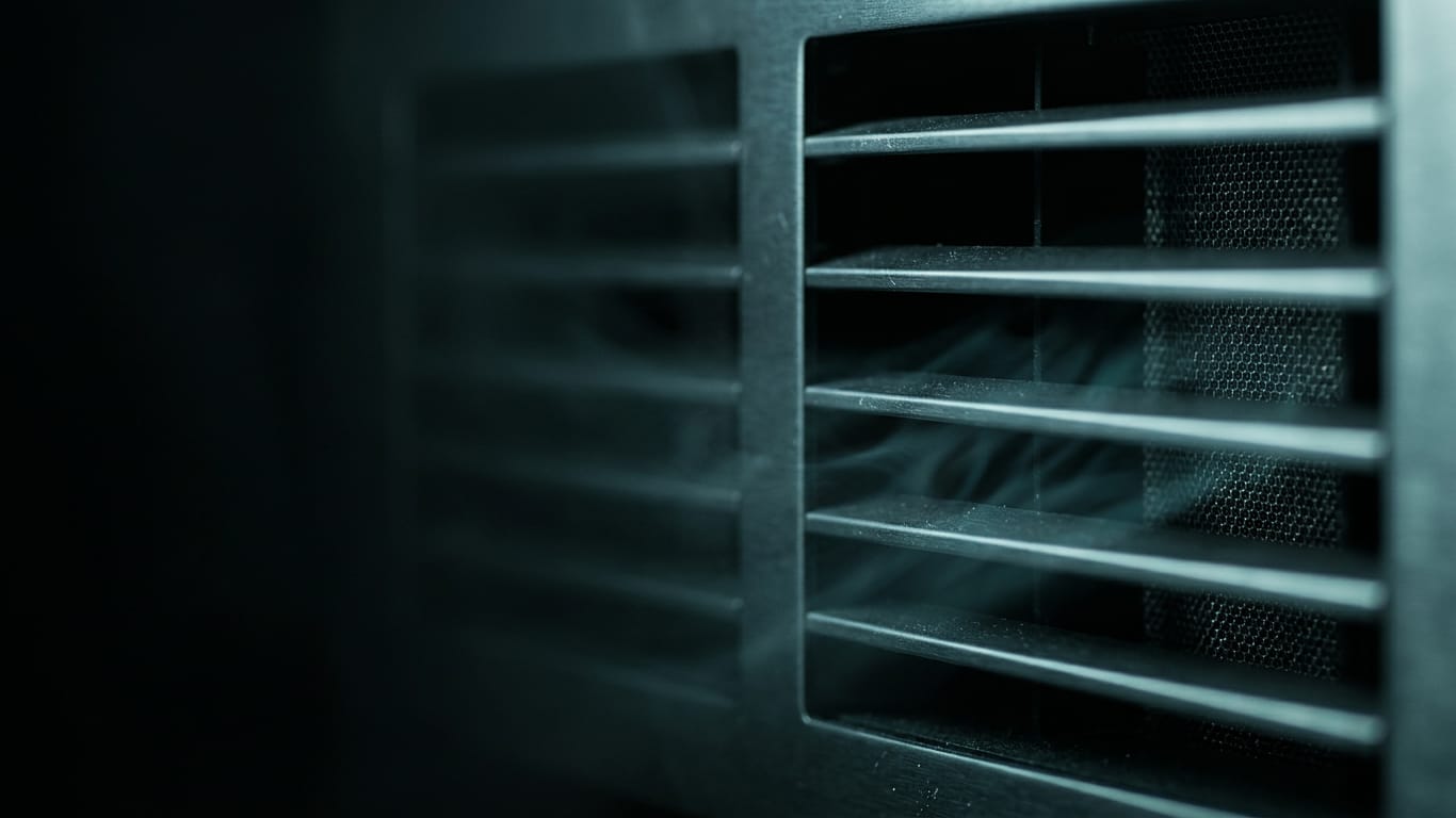 Illustration for this article: Human oversight of AI becomes a design requirement, not a signature. A ventilation grille in deep shadow, cold air distorting the light passing through it.