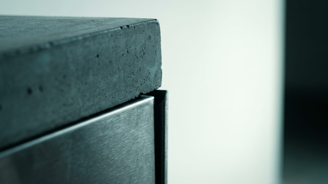 Illustration for this article: AI security alongside ISO 27001. Poured concrete meeting brushed steel at a tight seam, the joint slightly misaligned.