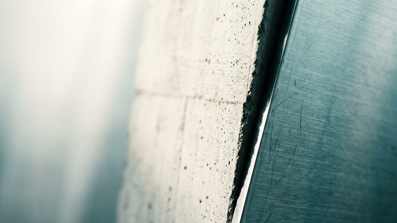 Illustration for this article: LLM Security in 2026. Poured concrete meeting brushed steel at a tight seam, the joint slightly misaligned.