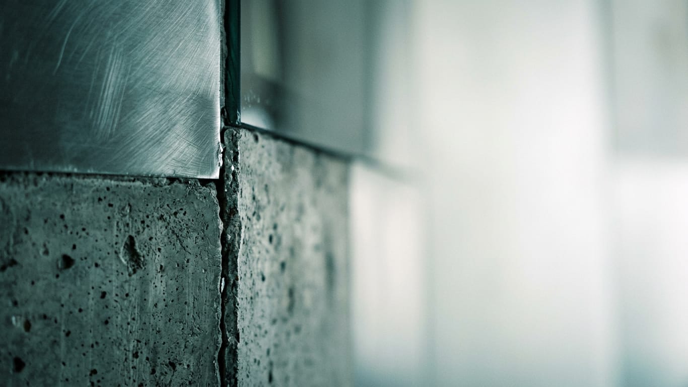 Illustration for this article: Managing multilingual privacy documents. Poured concrete meeting brushed steel at a tight seam, the joint slightly misaligned.