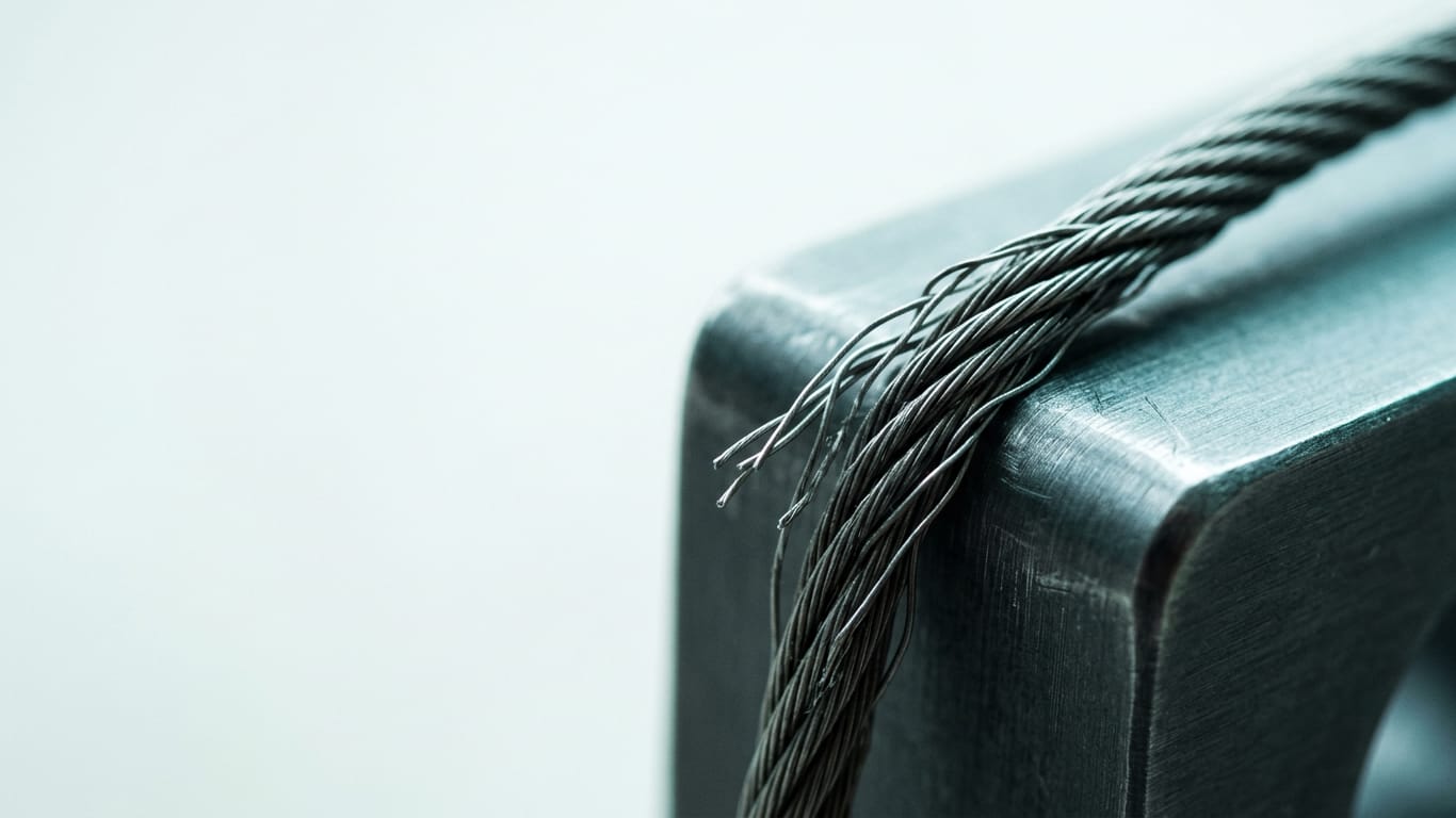 Illustration for this article: Ontario regulators IPC and OHRC transparency. A steel cable under visible tension, strands separating where it passes over an edge.